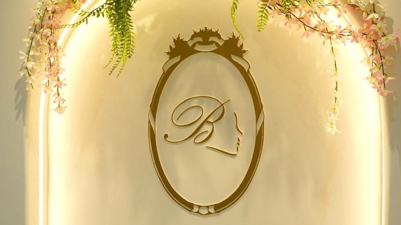 Gold monogram logo on the salon reception wall